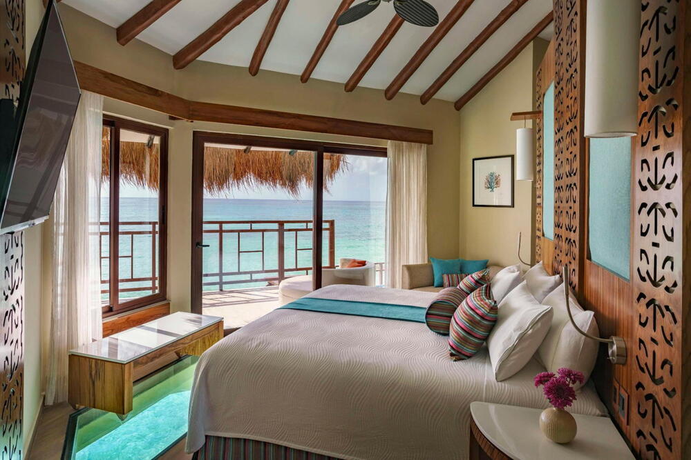 Palafitos Maroma — overwater bungalow guestroom interior
